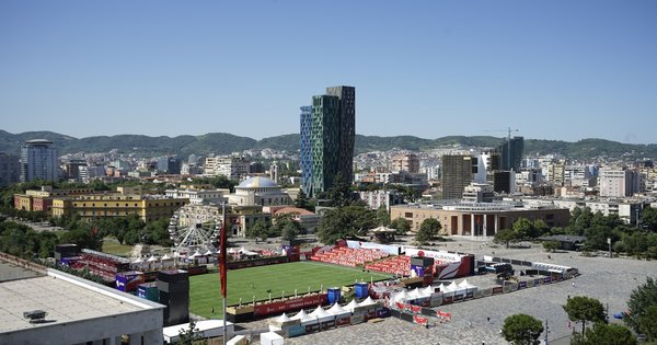 The Albanian and European Union flags flying together outside a government building in Tirana
