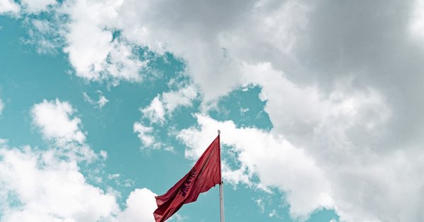 Albanian and European Union flags side by side outside a government building in Tirana