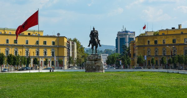 The Albanian parliament building in Tirana under a clear sky