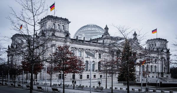 A rainbow flag flying against a European city skyline during Pride season