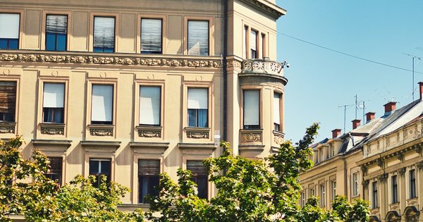 A pride flag against a Croatian street scene with traditional architecture