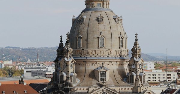 A rainbow flag flying above a baroque skyline in Dresden, Germany