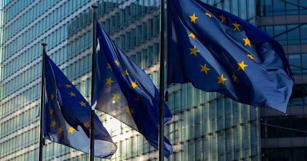 European Union flags waving in front of an EU institutional building