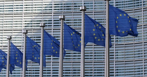 The European Commission Berlaymont building in Brussels with the EU flag flying outside.