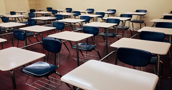 An empty American school classroom with desks and a chalkboard