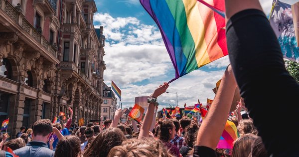 A rainbow Pride flag held up by demonstrators in a European city