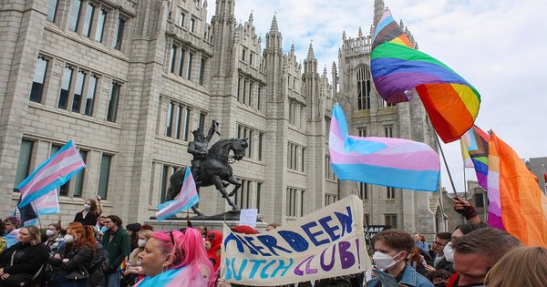 Demonstrators holding transgender pride flags at a trans rights protest