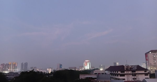 The Jakarta skyline at dusk, high-rise towers against a fading sky