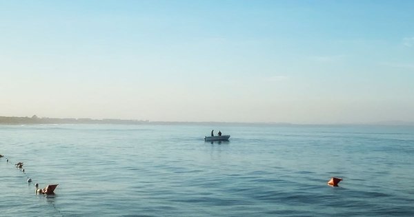 A small boat on the calm Adriatic Sea off Durrës beach on a clear morning
