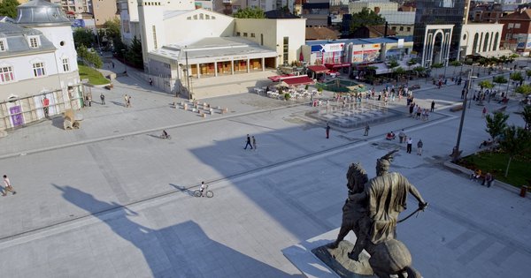 A street-level view of downtown Pristina, Kosovo, showing city architecture and a pedestrian area