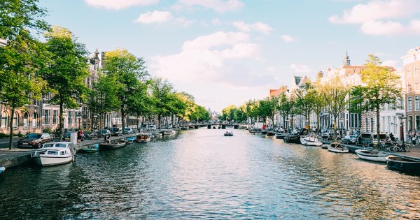 Rainbow flags and pride banners along an Amsterdam canal during WorldPride.