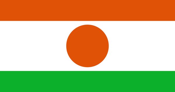 The flag of Niger, orange, white and green, against an open sky