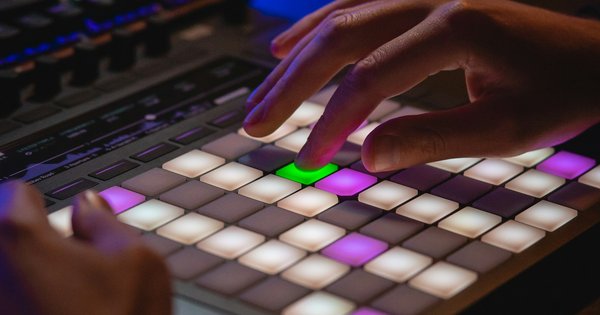 A person's hands typing on a laptop keyboard, backlit