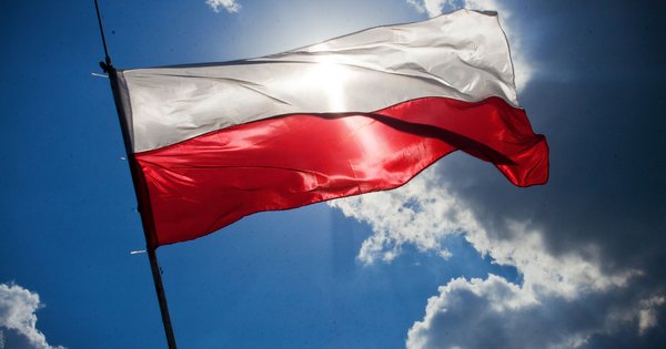 The Polish flag flying against a bright blue sky