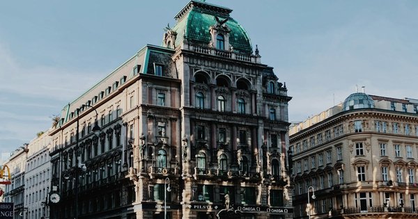 Vienna's Ringstrasse with the spires of Votivkirche in the background, framed by green trees