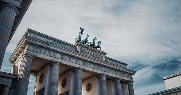 The Brandenburg Gate in Berlin lit in rainbow colors at dusk